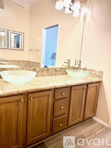 A bathroom with two sinks and wooden cabinets.