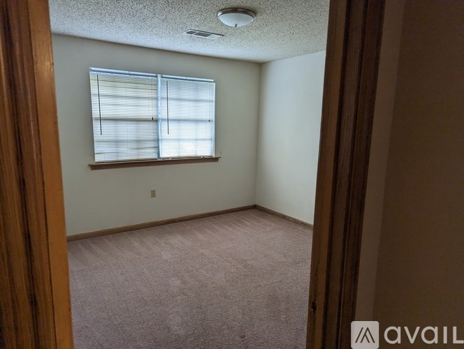 A room with a window and carpeted floor.