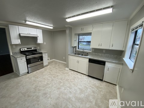 A kitchen with white cabinets and a stove top oven.