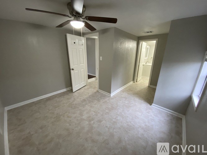 A room with a ceiling fan and two doors.