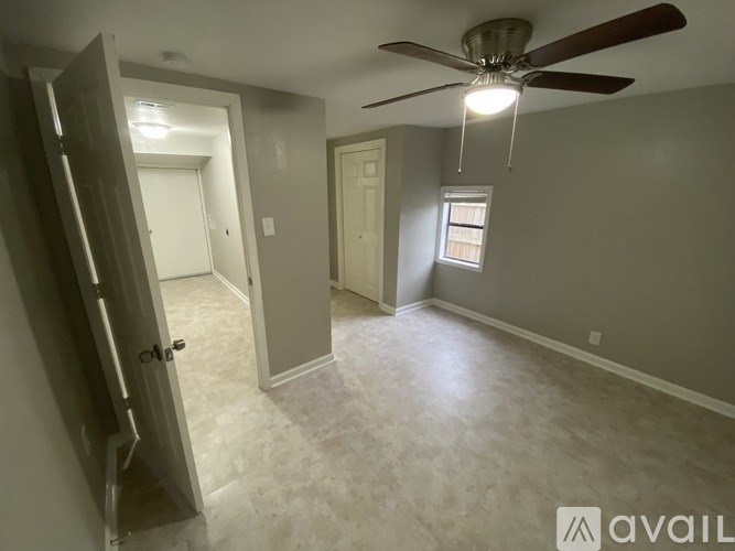 A room with a ceiling fan and a window.