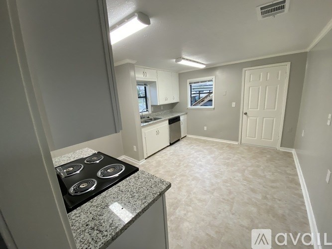 A kitchen with a granite countertop and stove top.