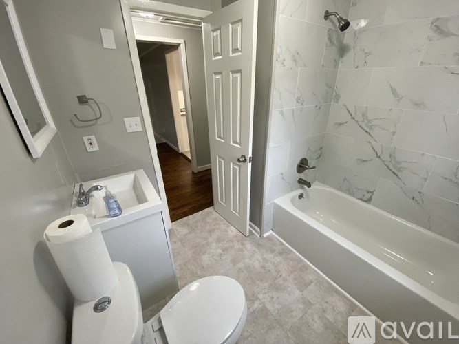 A bathroom with a toilet, sink, and bathtub.
