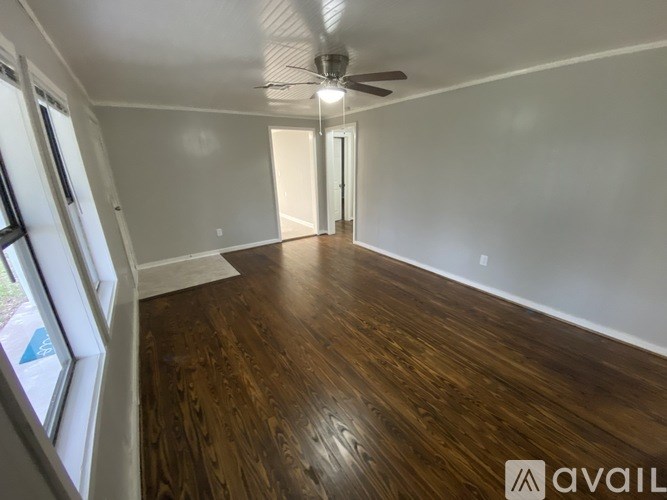 A room with wooden flooring and a ceiling fan.