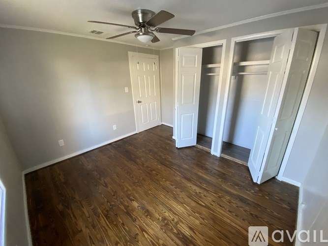 A room with wooden floors and a ceiling fan.