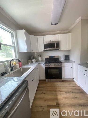 A kitchen with white cabinets and a black stove top oven.