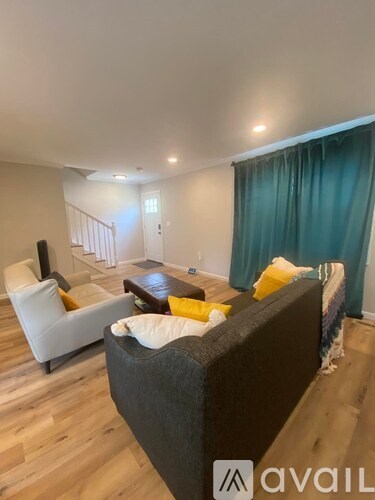 A living room with a grey couch and a white chair.