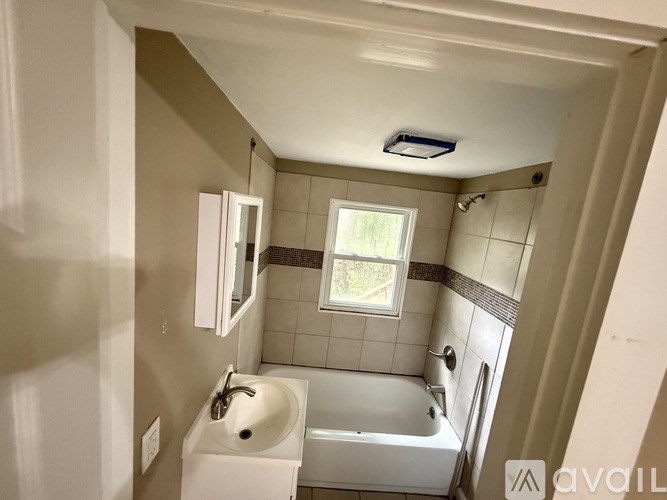 A bathroom with a white sink and bathtub.