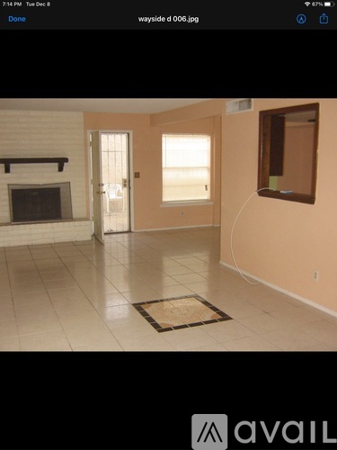 A room with a fireplace and a door leading outside.