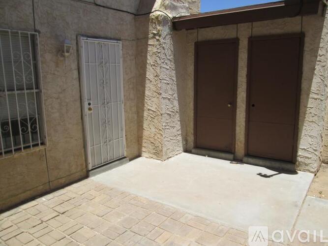 A stone building with a white door and a brown door.
