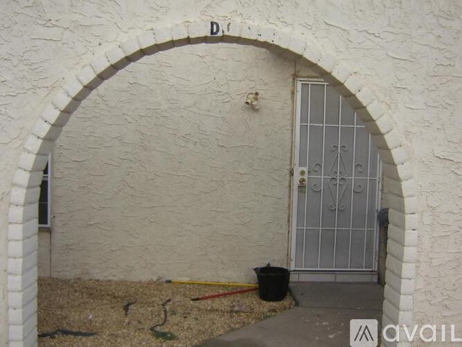 A white archway leads to a metal gate.