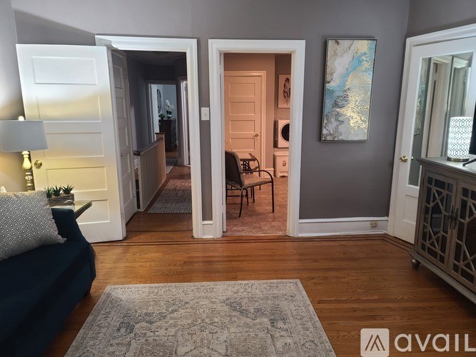 A living room with a blue couch and a rug in the foreground.