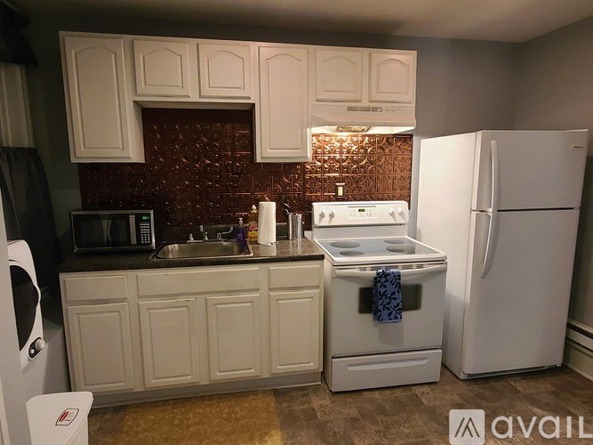 A kitchen with white appliances and cabinets.