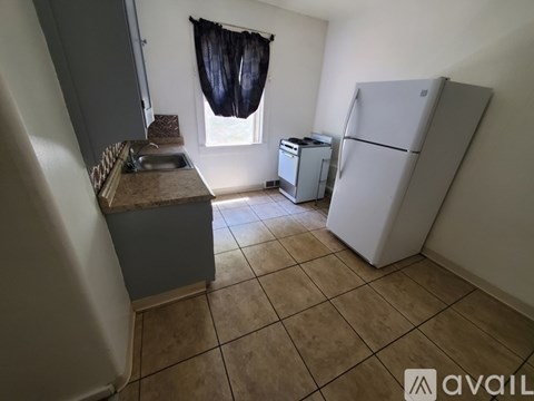 A kitchen with a refrigerator, sink, and dishwasher.