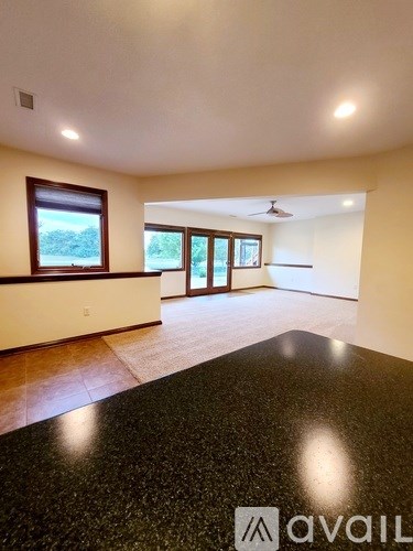 A spacious room with a black granite countertop and a ceiling fan.
