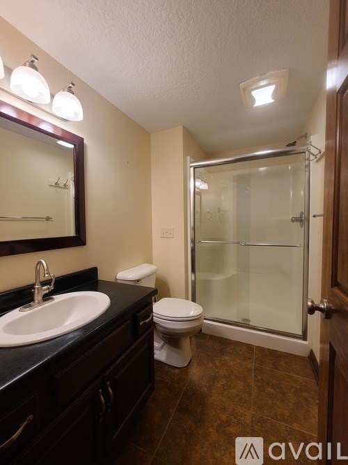 A bathroom with a sink, toilet, and shower.