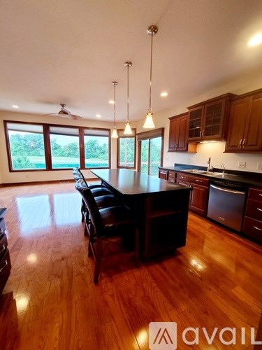 A kitchen with wooden floors and a large island in the middle.