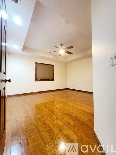 A room with wooden flooring and a ceiling fan.