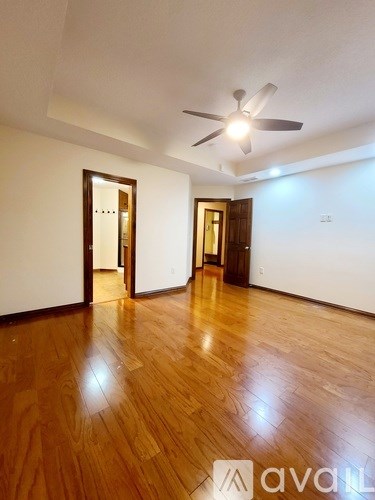 A room with wooden floors and a ceiling fan.