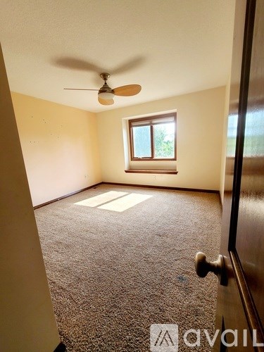 A room with a ceiling fan and a window.