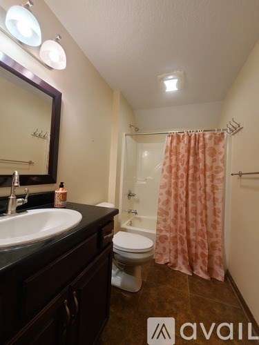A bathroom with a sink, toilet, and shower.