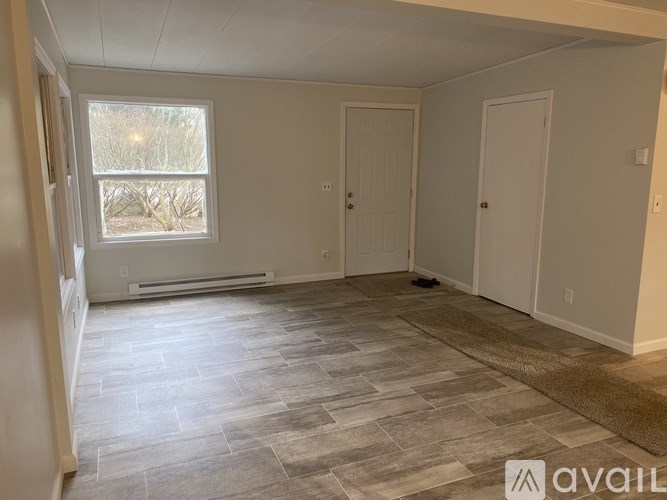 A room with a window and a tiled floor.