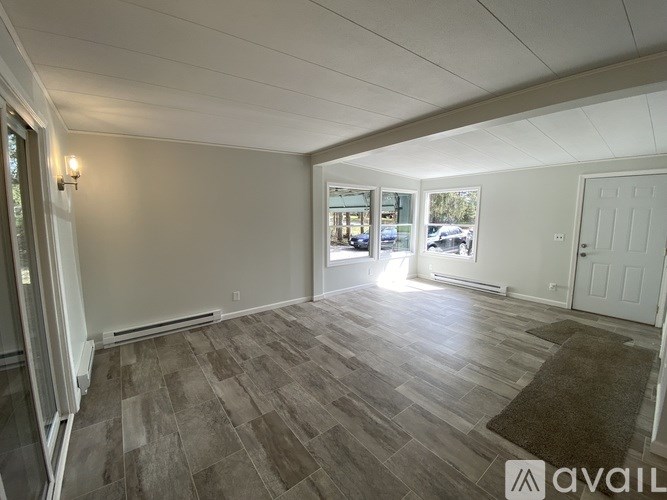 A room with a wooden floor and white walls is available for rent.