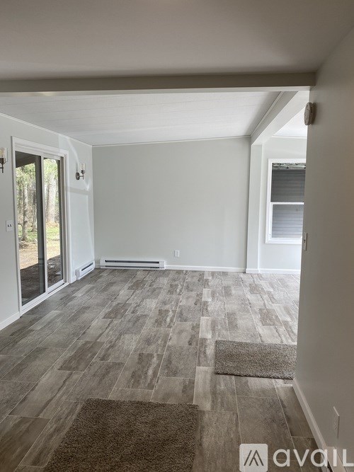A room with a carpeted floor and a sliding glass door.