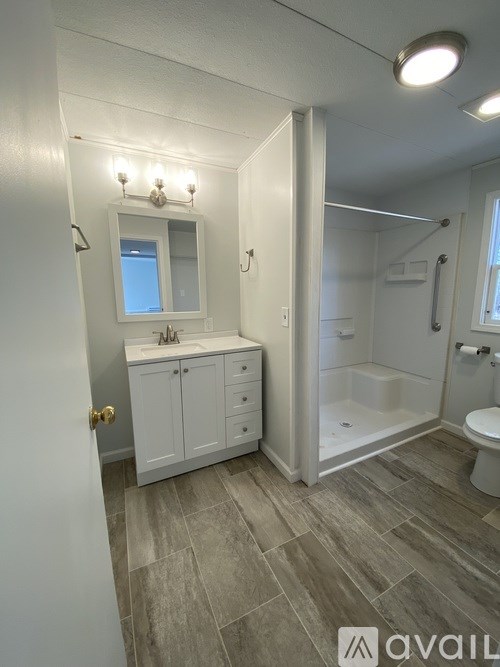 A bathroom with a toilet, sink, and a mirror.
