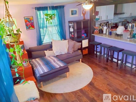 A living room with a grey couch and a wooden floor.