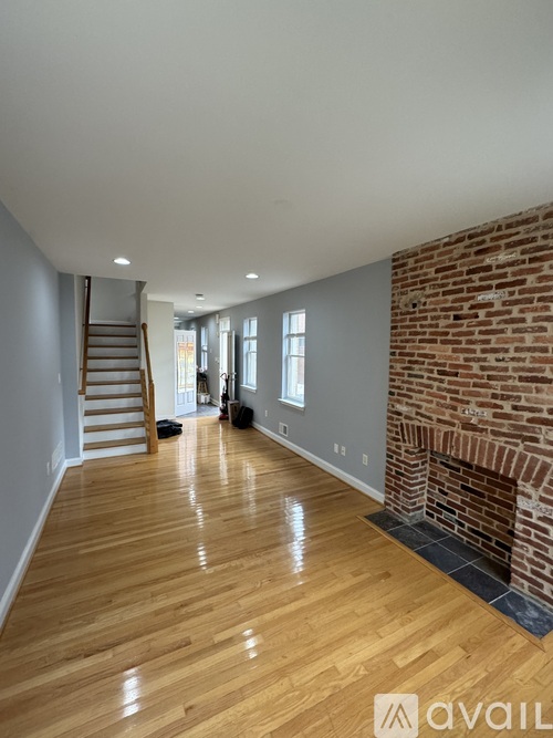 A living room with a brick wall and a flat screen TV.