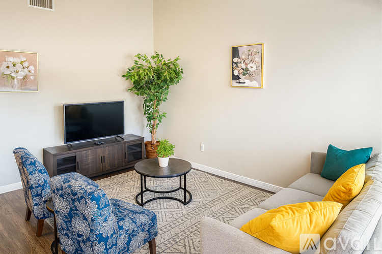 A living room with a blue chair and a grey couch.