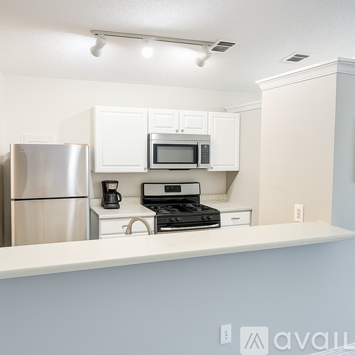 A kitchen with white cabinets and appliances.