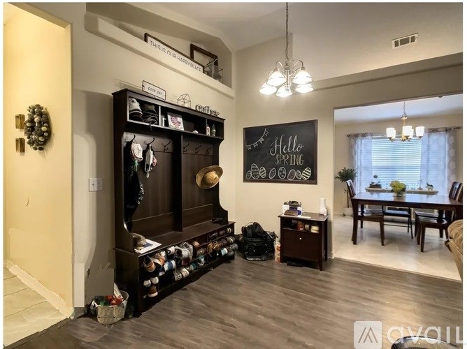 A living room with a chalkboard on the wall that says "Hello Spring".