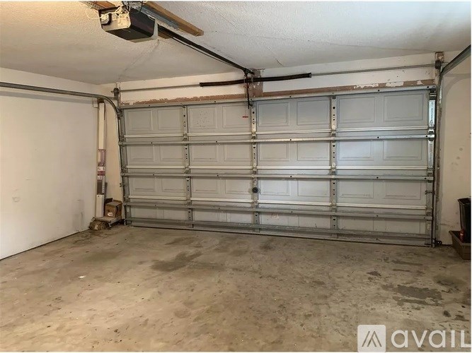 A large garage door is closed and the garage is empty.