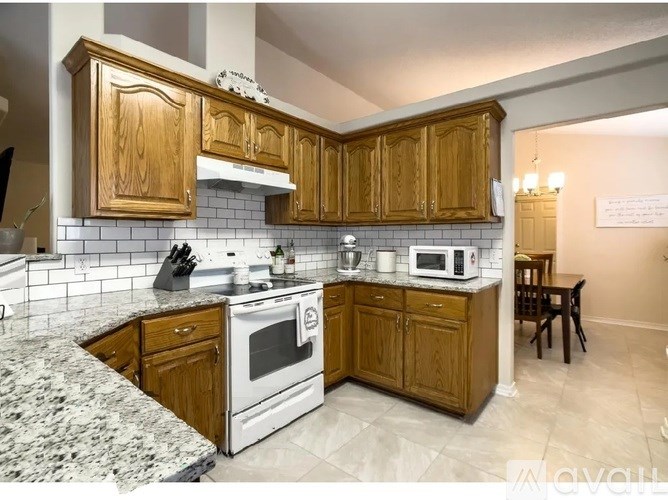 A kitchen with wooden cabinets and a granite countertop.