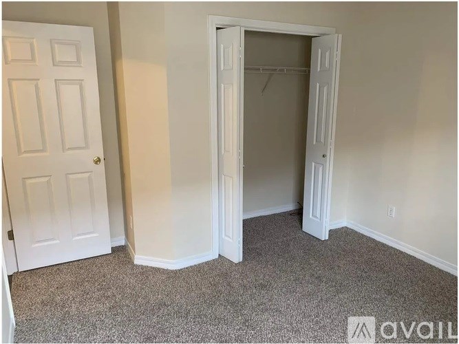 A room with a white door and a white closet door.