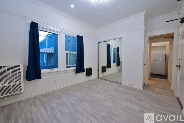 A room with a window, a door, and a mirror.