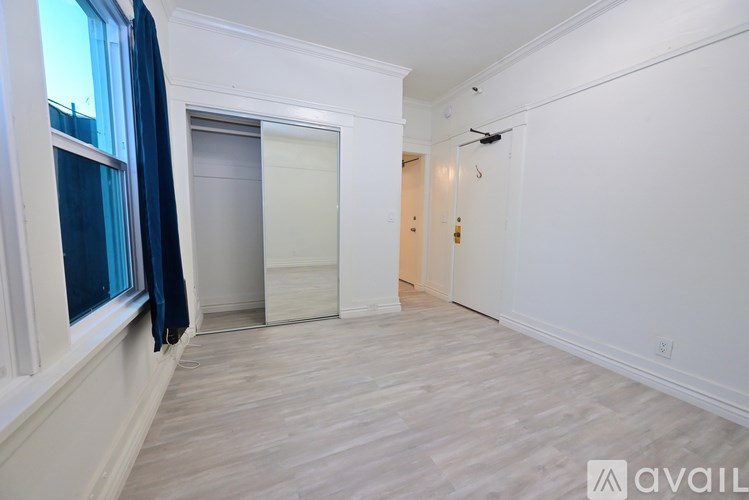 A room with a white wall and a wooden floor.