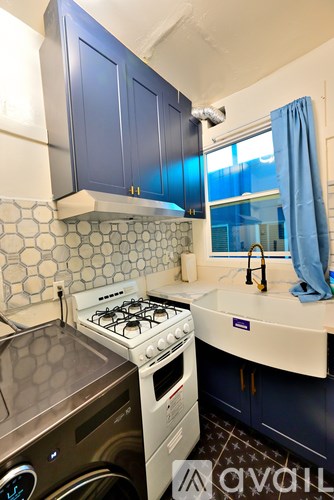 A kitchen with a white stove top oven and a washing machine.