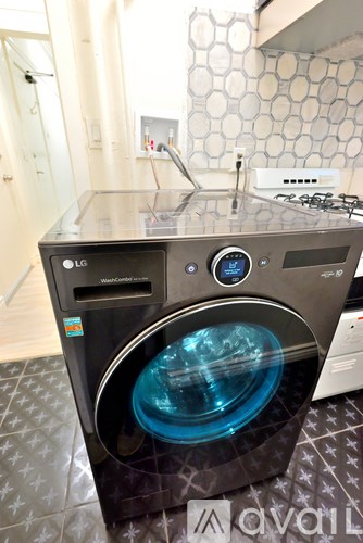 A black and silver LG front load washing machine with a blue light on the door.