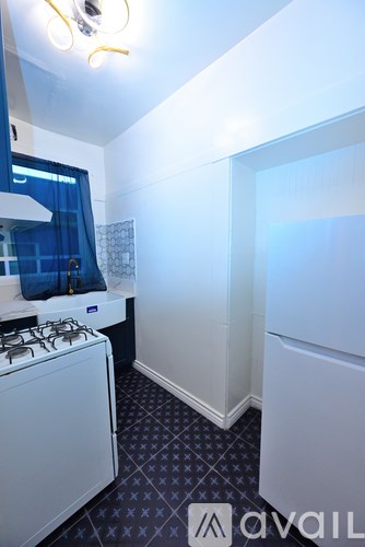 A small white kitchen with a gas stove and a window.