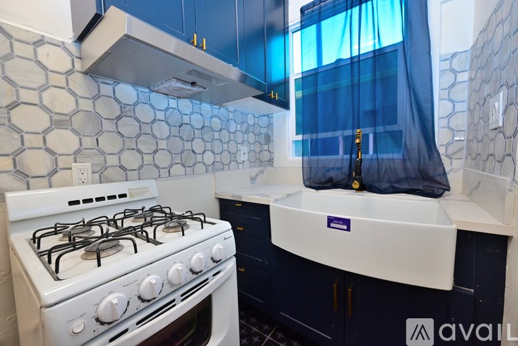 A kitchen with a white gas stove and blue cabinets.