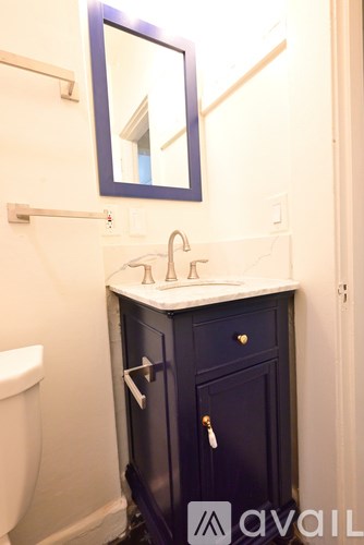 A bathroom with a sink, toilet and a cabinet.