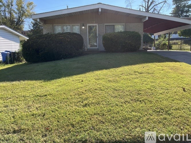 A house with a green lawn in front of it.