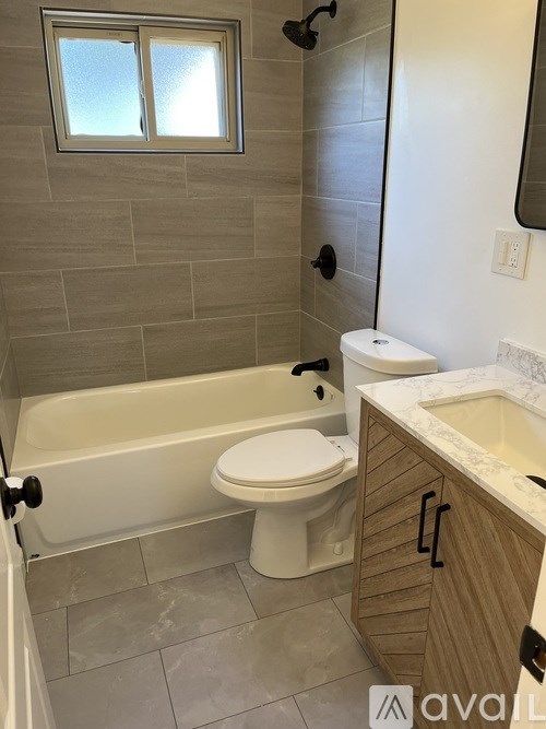 A bathroom with a toilet, sink, and tub.