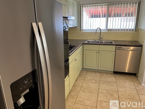 A kitchen with a stainless steel refrigerator and a dishwasher.