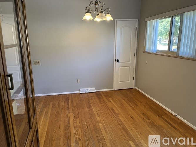 A room with wooden flooring and a white door.