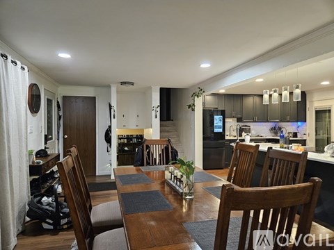 A living room with a wooden bookcase and a staircase.