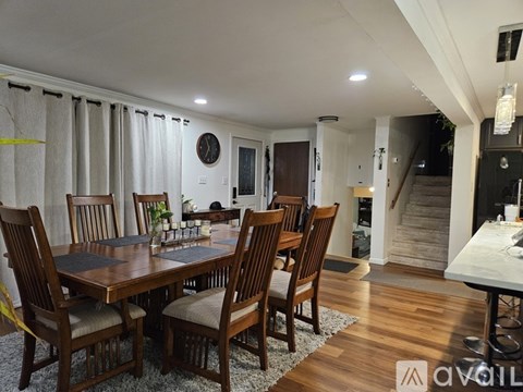 A bedroom with two beds, one with a floral pattern, and a nightstand with a lamp.